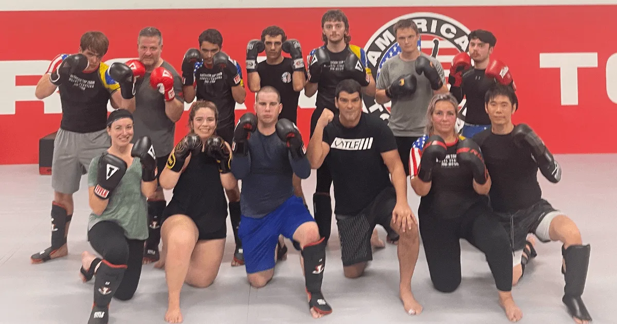Adult Martial artists wearing gloves and shin guards after training