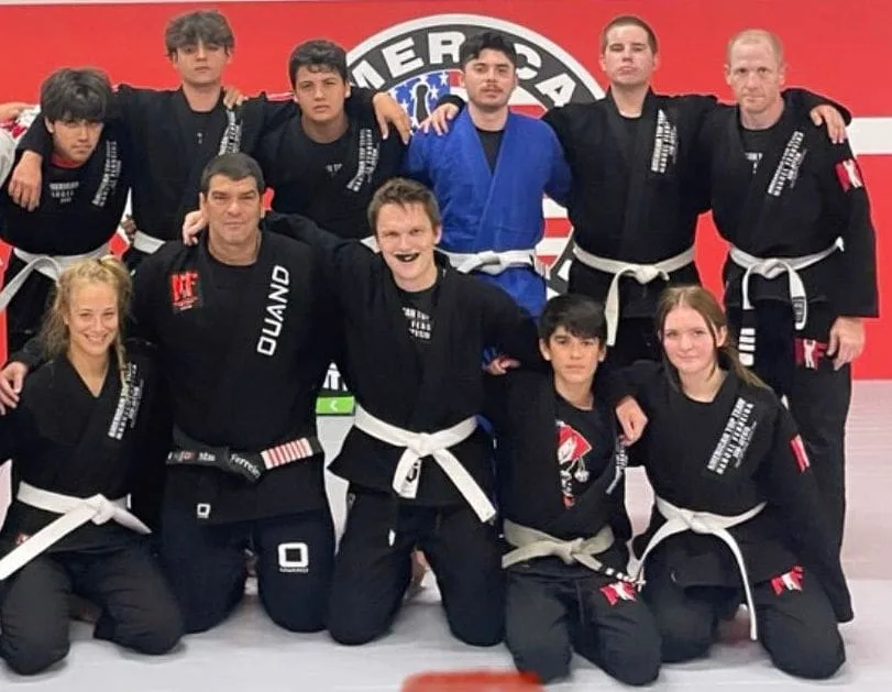 Confident adult students smiling in Brazilian Jiu-Jitsu gis