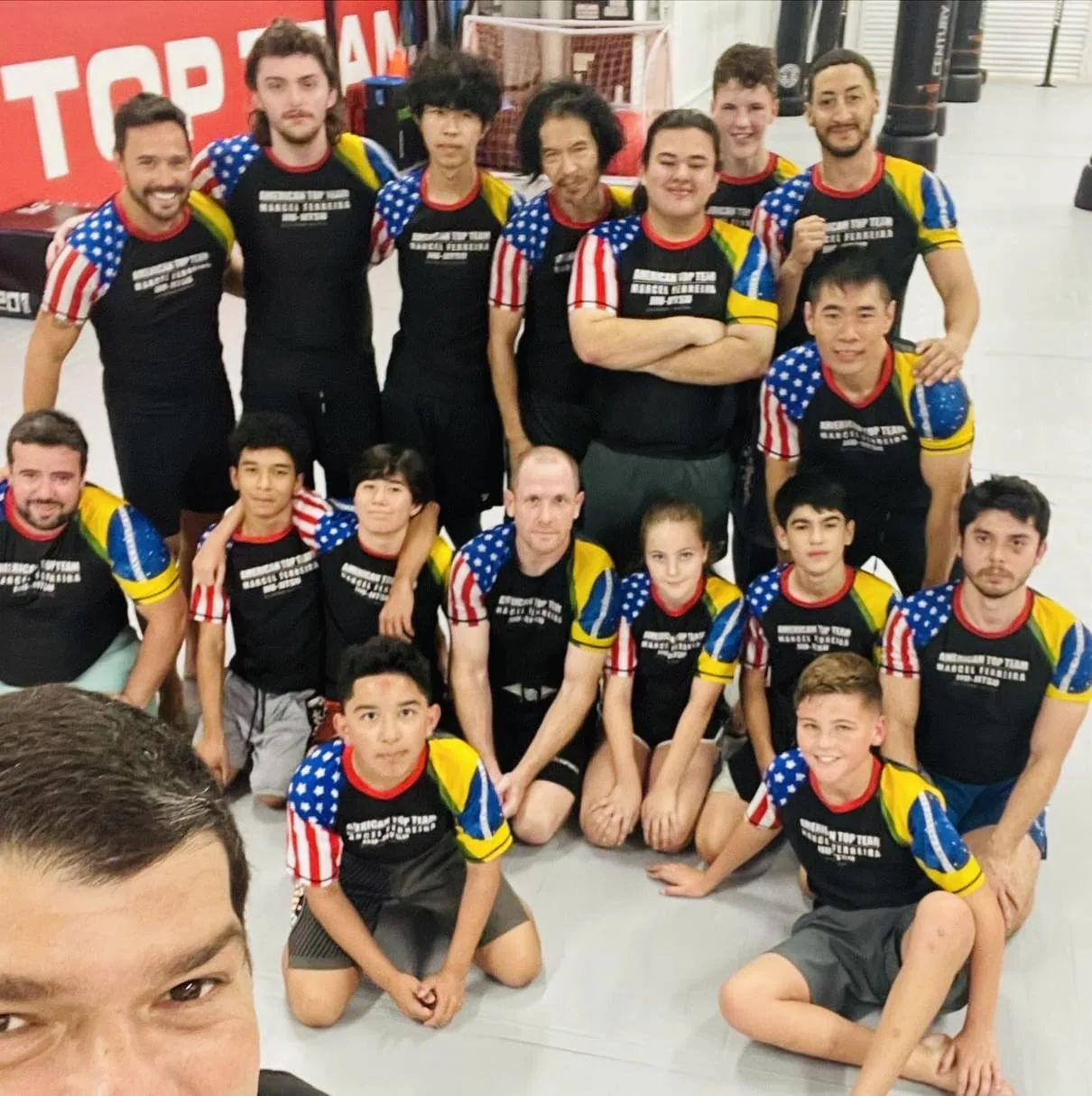 Adults in Brazilian Jiu-Jitsu posing together after training