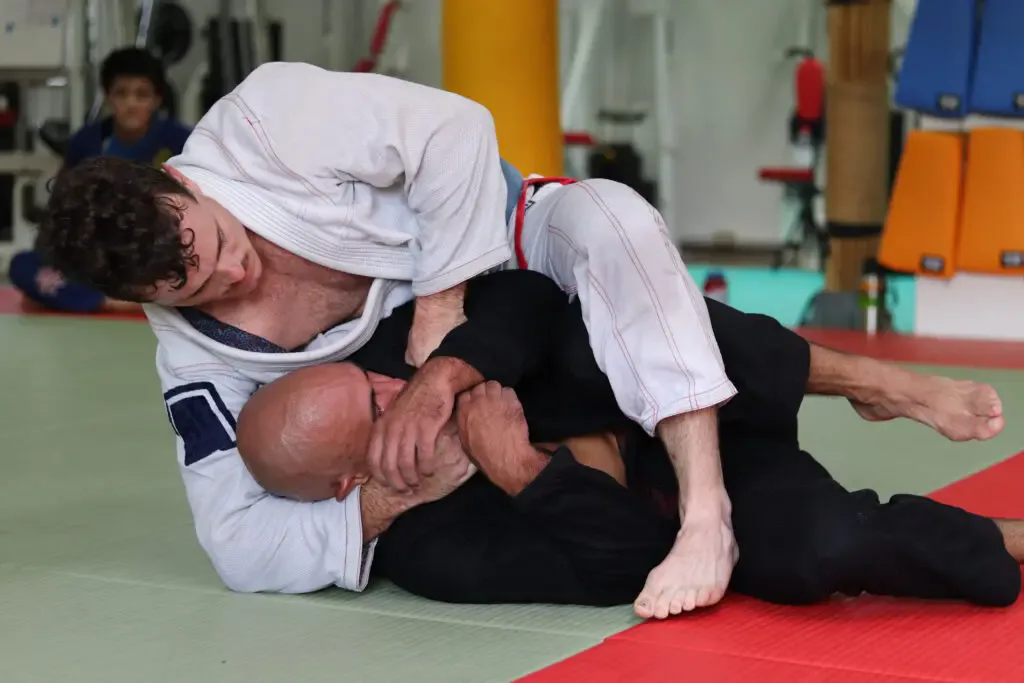 Adult showcasing advanced jiu jitsu skills in a training session