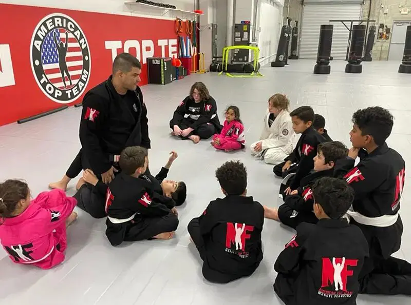 group of kids listening to a mentor during a martial arts class