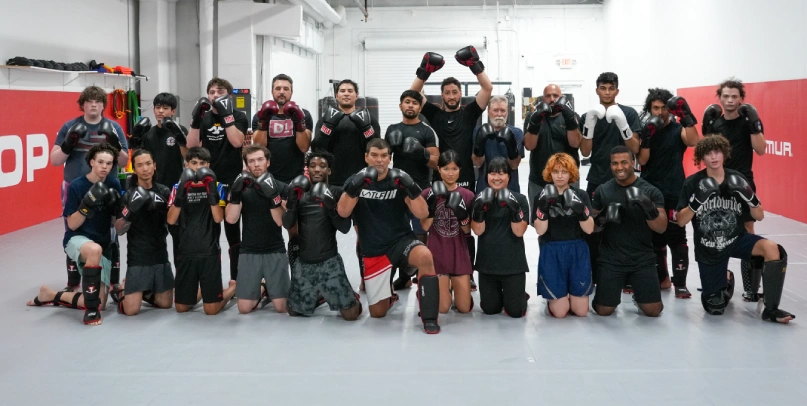 Brazilian Jiu-Jitsu class smiling confidently on the mats after training